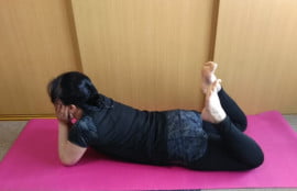 うつ伏せに寝て肘を立て足を曲げてかかとでお尻をポンポン叩く写真