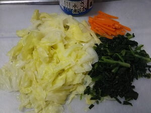 さば水煮缶と冷蔵庫にある野菜を切った写真