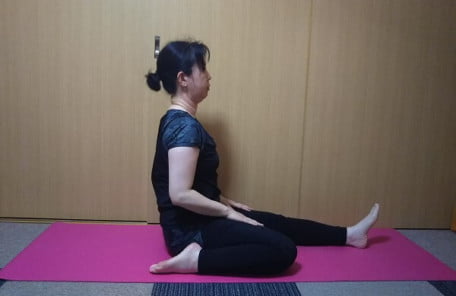 座って左足を伸ばし、右足を曲げたストレッチの写真