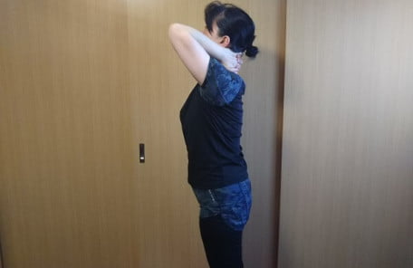 両手で首を持っている写真