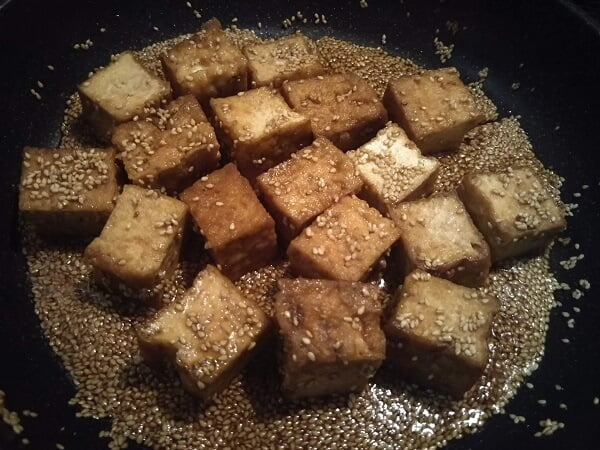 フライパンを熱して厚揚げ、調味料、ごまを入れた写真