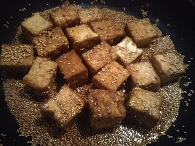 フライパンを熱して厚揚げ、調味料、ごまを入れた写真