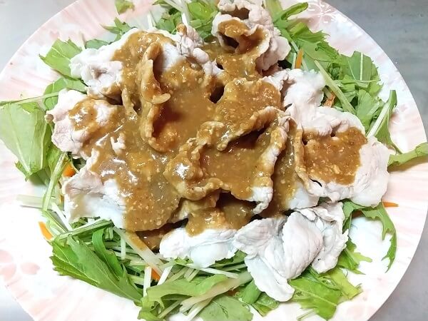 水菜、にんじんの上に豚肉をのせごまだれをかけた写真