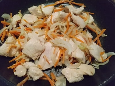 にんじん、玉ねぎ、鶏むね肉を入れて炒めた写真