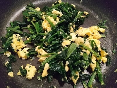 ほうれん草を炒め卵を戻し味付けする写真