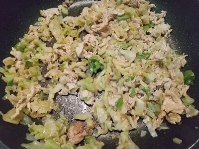 フライパンできゃべつと豚肉を炒める写真