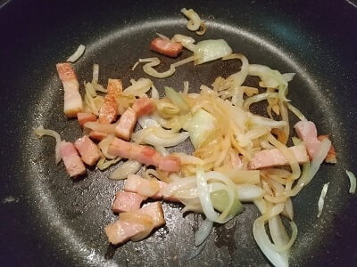 フライパンでベーコンと玉ねぎを炒める
