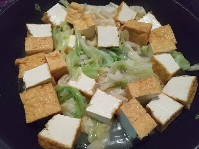 フライパンで厚揚げときゃべつを炒める写真