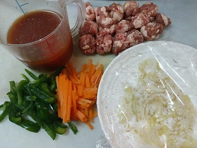 野菜を切って玉ねぎはレンチンし豚肉を丸め調味料を合わせた写真