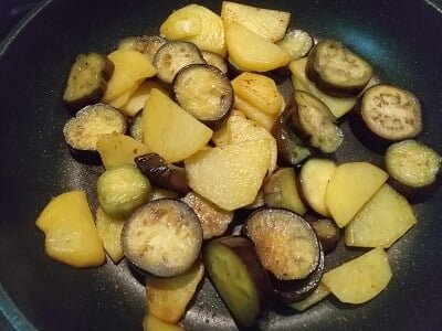 じゃがいもから焼いて火が通ったらなすを入れしんなりしたら調味料も入れて焼く写真