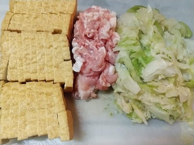 厚揚げ、豚こま、きゃべつを食べやすい大きさに切る