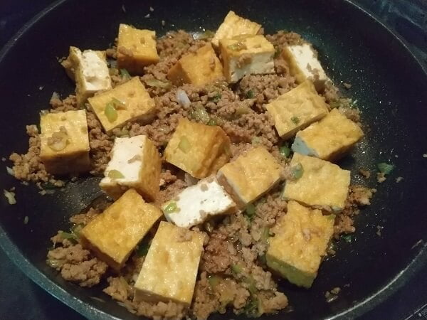 When the minced meat is cooked, add the green onions, miso, and fried tofu.
