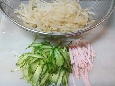 きゅうり、ハムを切ってもやしを茹でる