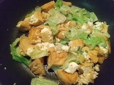 フライパンに厚揚げを入れ軽焦げ目がつくまで炒め、キャベツも入れる