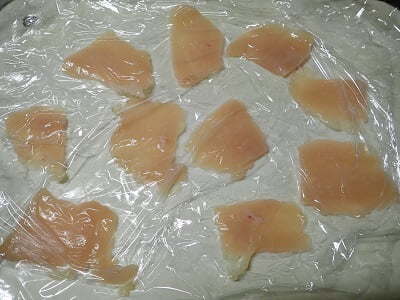 鶏むね肉をラップで包んで薄く叩く