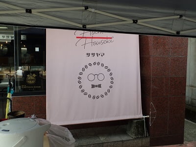 まんぷくクッキーササヤマ時計店前テント販売のお店の可愛いメガネのマークの写真